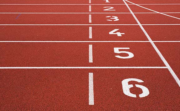 Orange athletics track with numbers painted in white. 